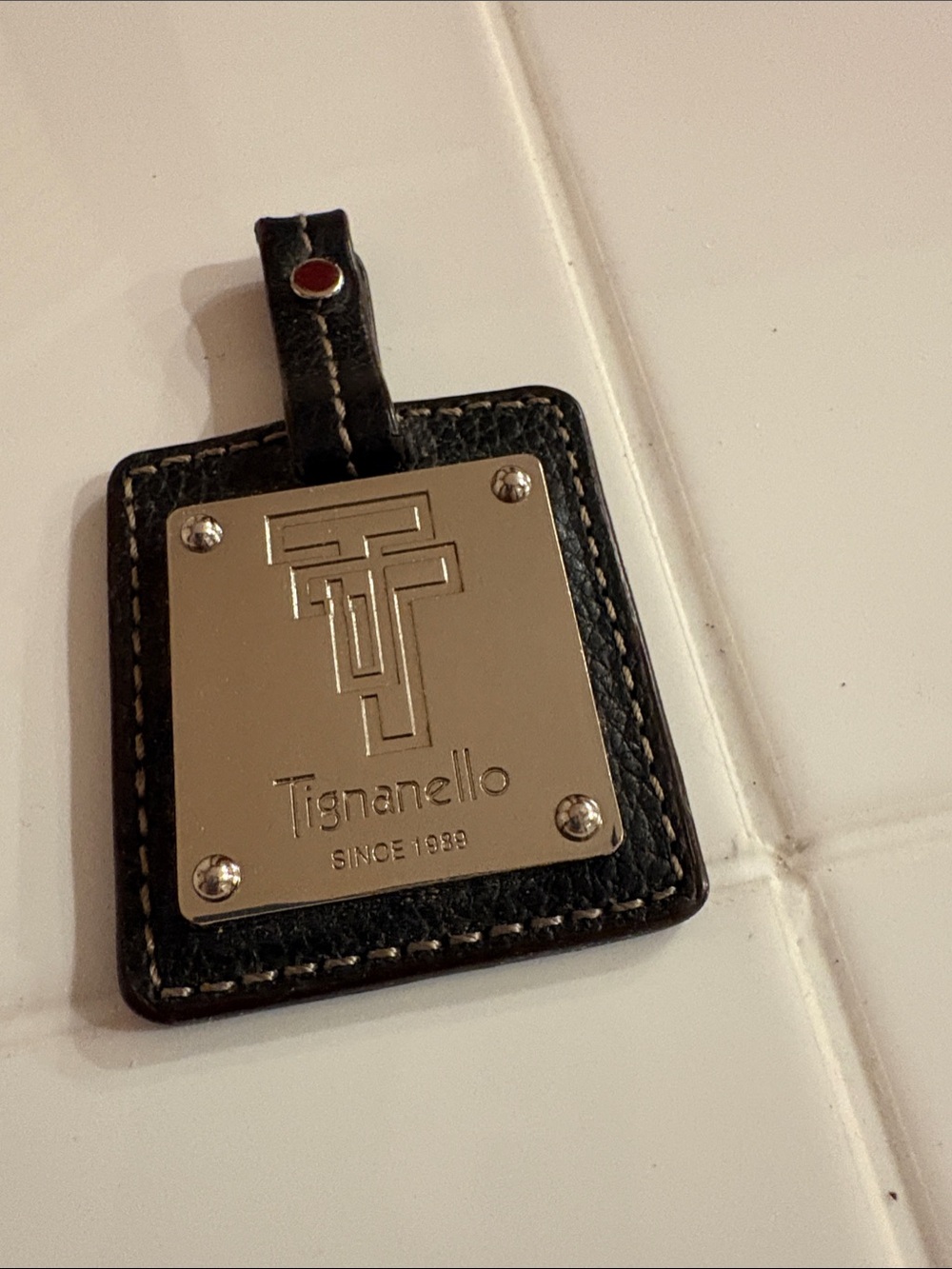 Tignanello Black Leather Tag with Silver Logo Plate